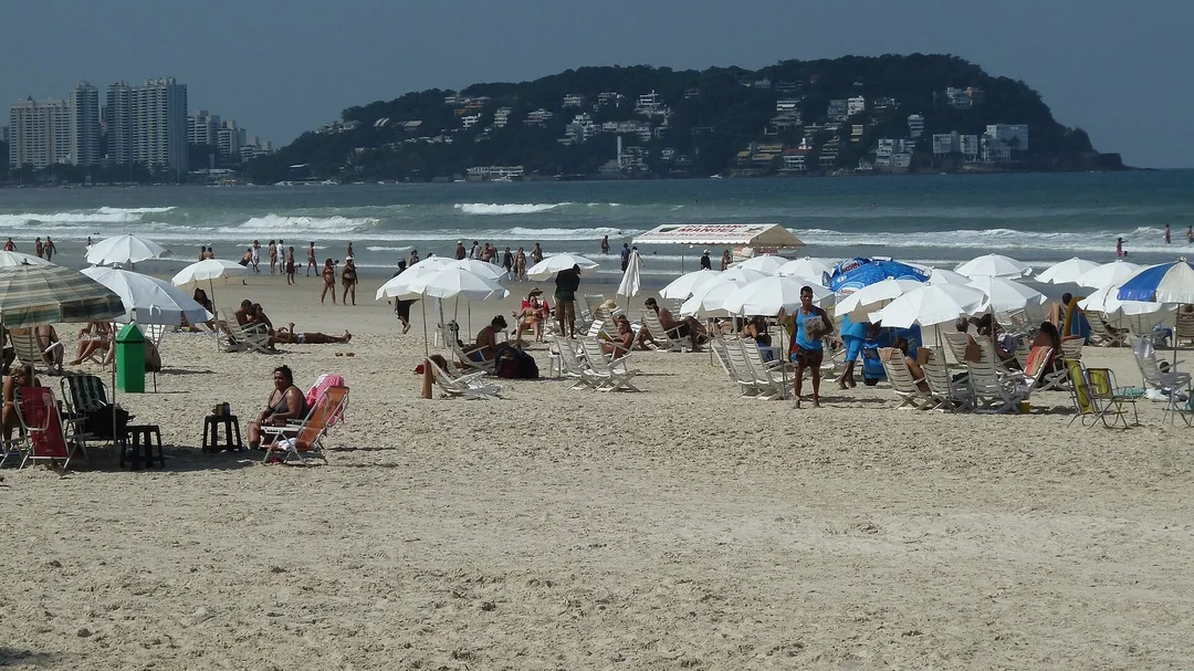 Banhistas e guarda-sóis na Praia da Enseada, em Guarujá (SP)