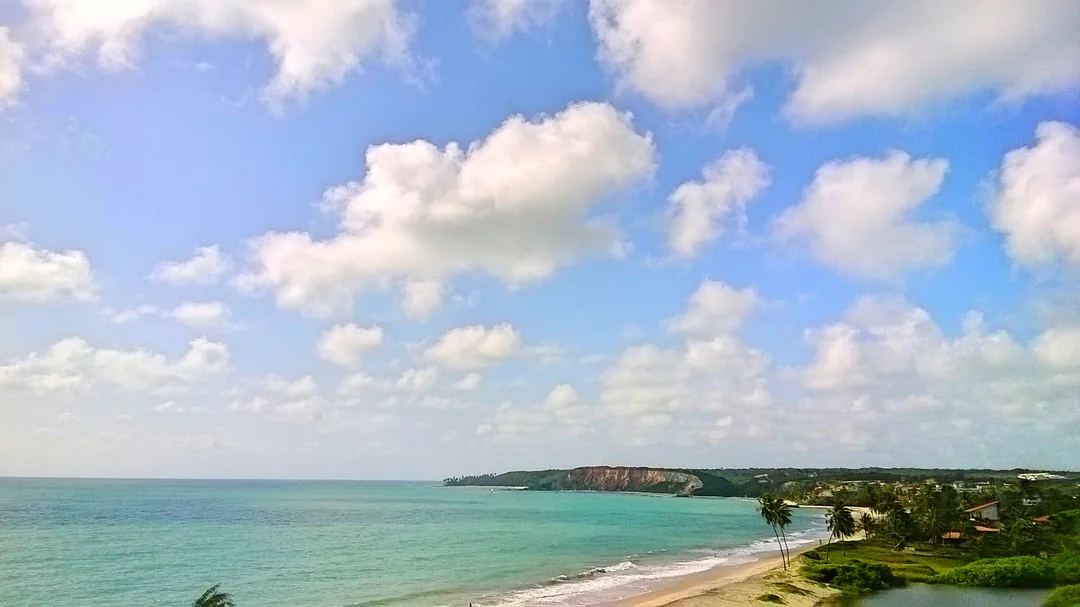 Mar e faixa de areia da praia de Jacumã sob céu de nuvens, em Conde (PB)