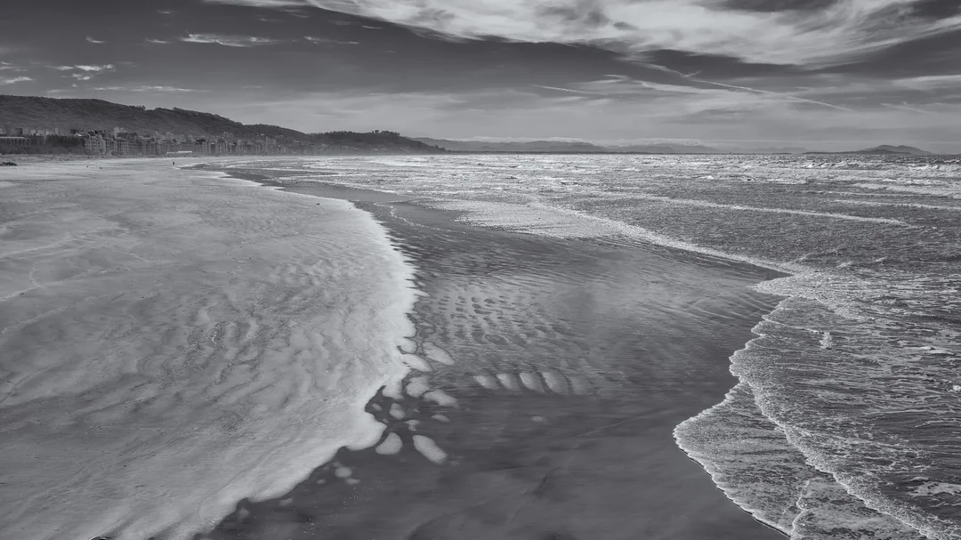 Faixa de areia e ondas da praia do Mar Grosso, em foto preto e branco, em Laguna (SC)