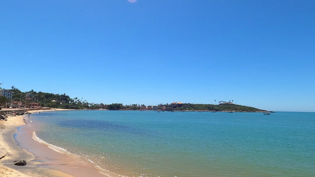 Faixa de areia curva e mar calmo na Praia de Meaípe, em Guarapari (ES)