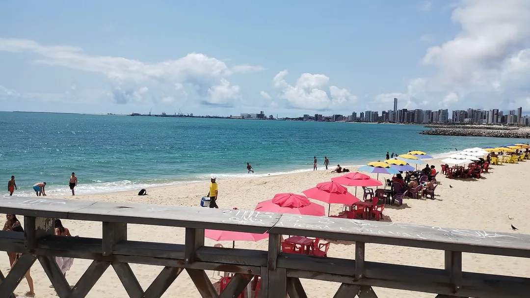 Barracas e areia da Praia de Iracema vistas do calçadão, em Fortaleza (CE)