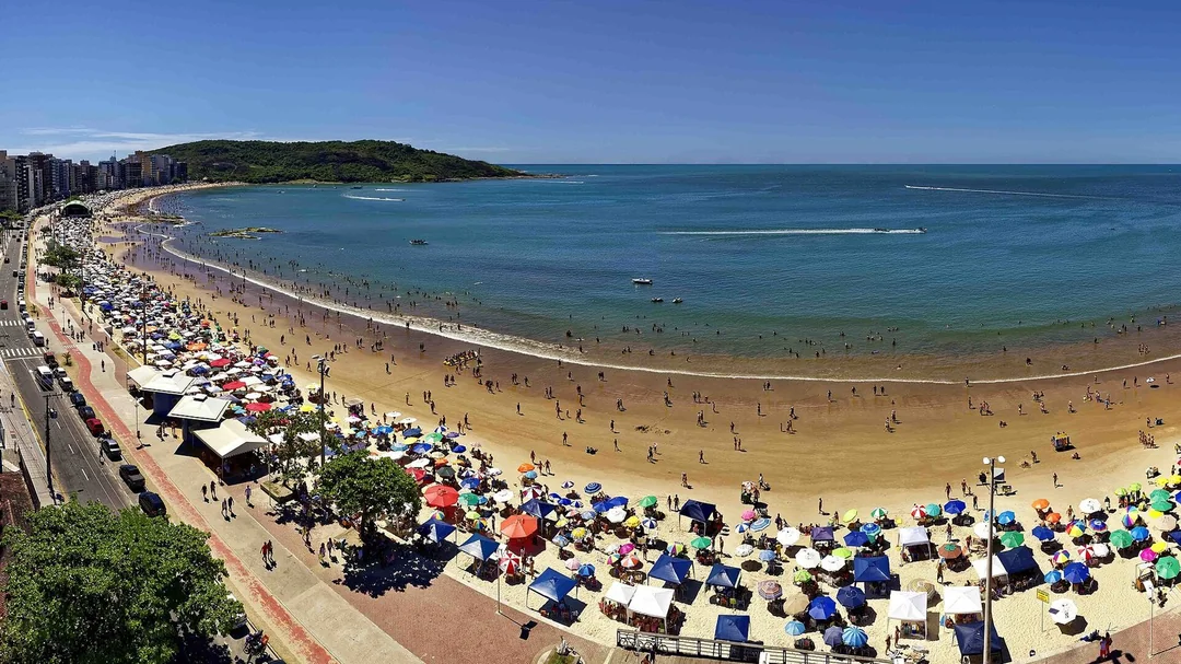 Vista do alto da Praia do Morro cheia no verão, em Guarapari (ES)