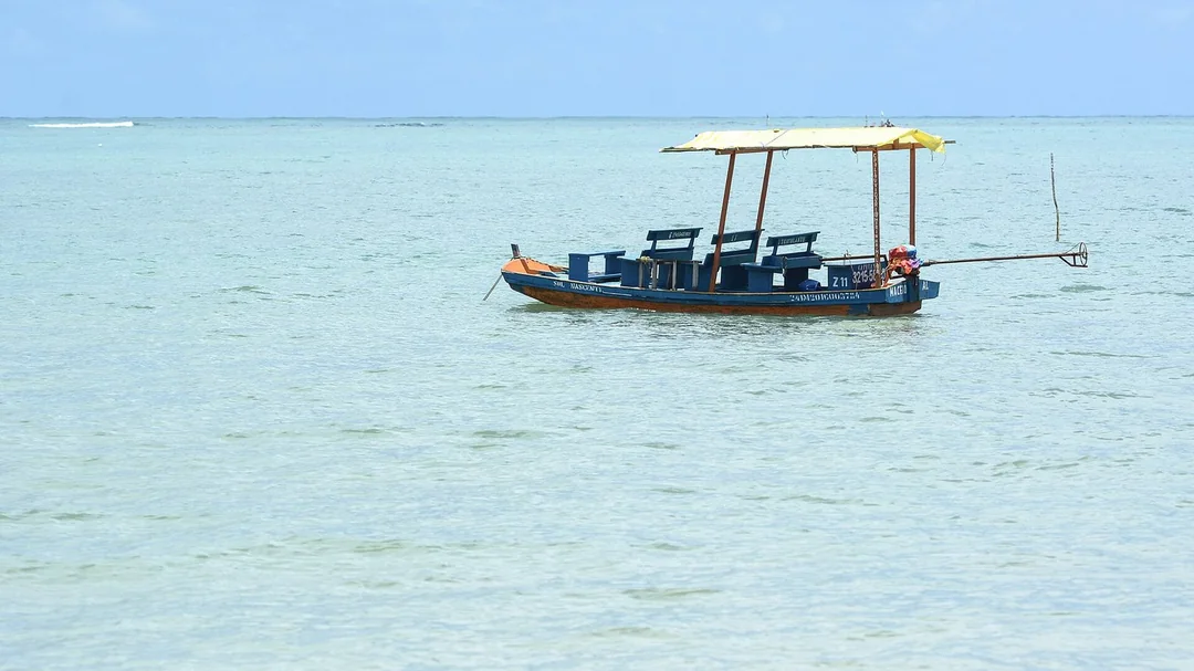 Barco ancorado no mar transparente da Praia do Toque, em São Miguel dos Milagres (AL)