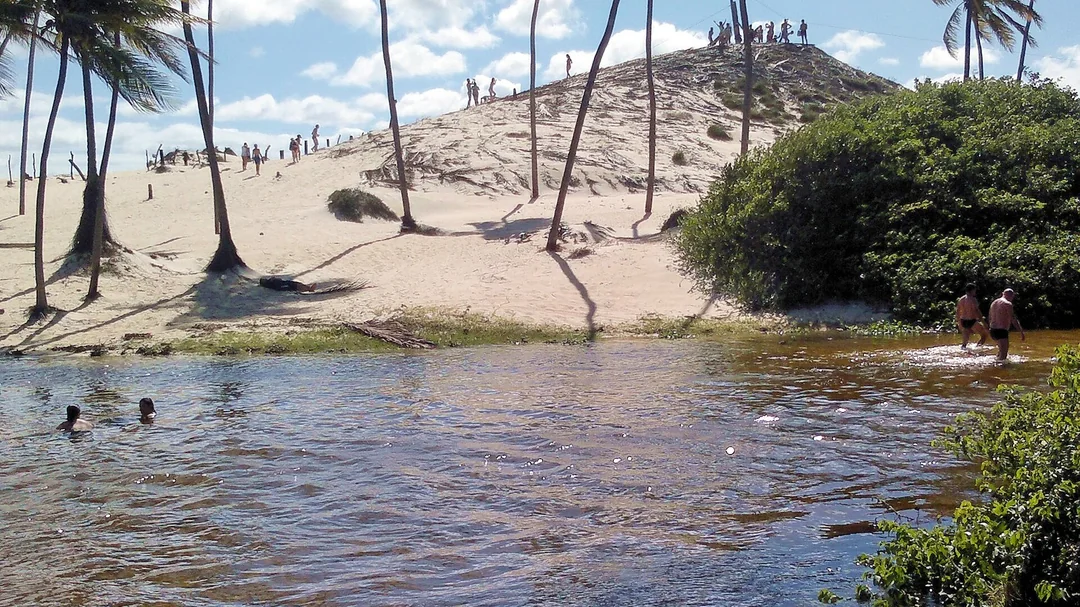 Rio, dunas e coqueiros em Rio do Fogo (RN)