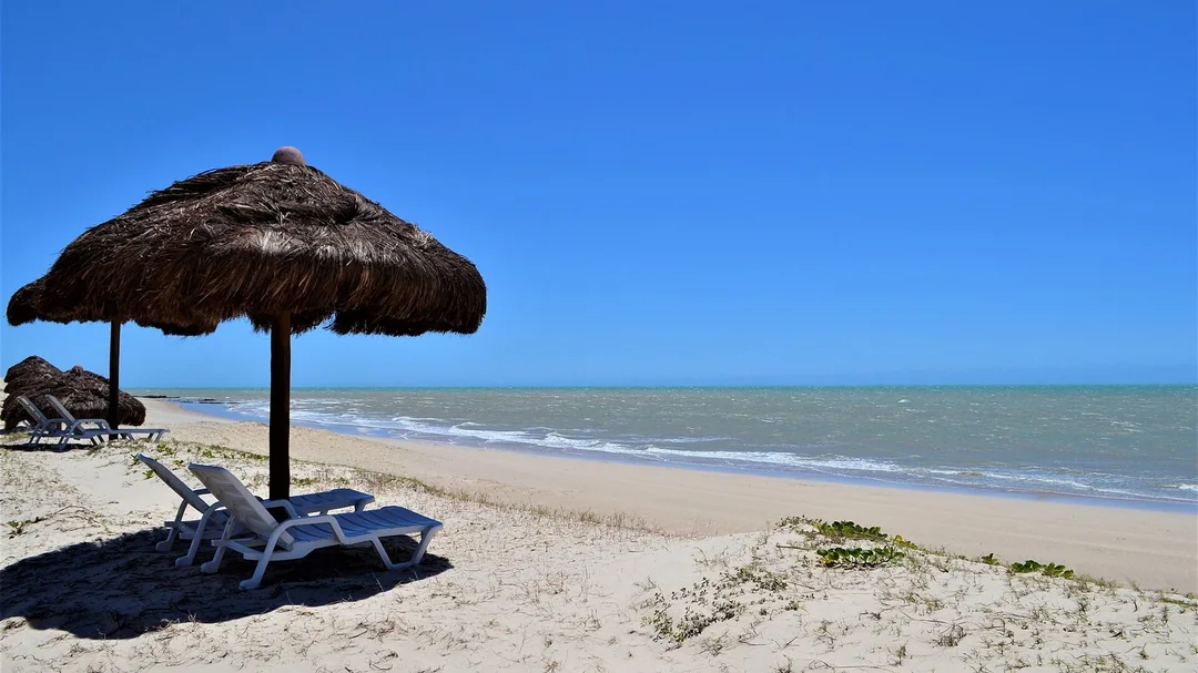 Quiosque de palha na areia de uma praia em Touros (RN)